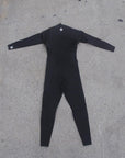 back side of full body wet suit while laying on ground. I P D circle logo at base of neck and on right wrist
