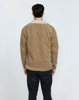 The back view of a man wearing a brown corduroy jacket with a sherpa collar.