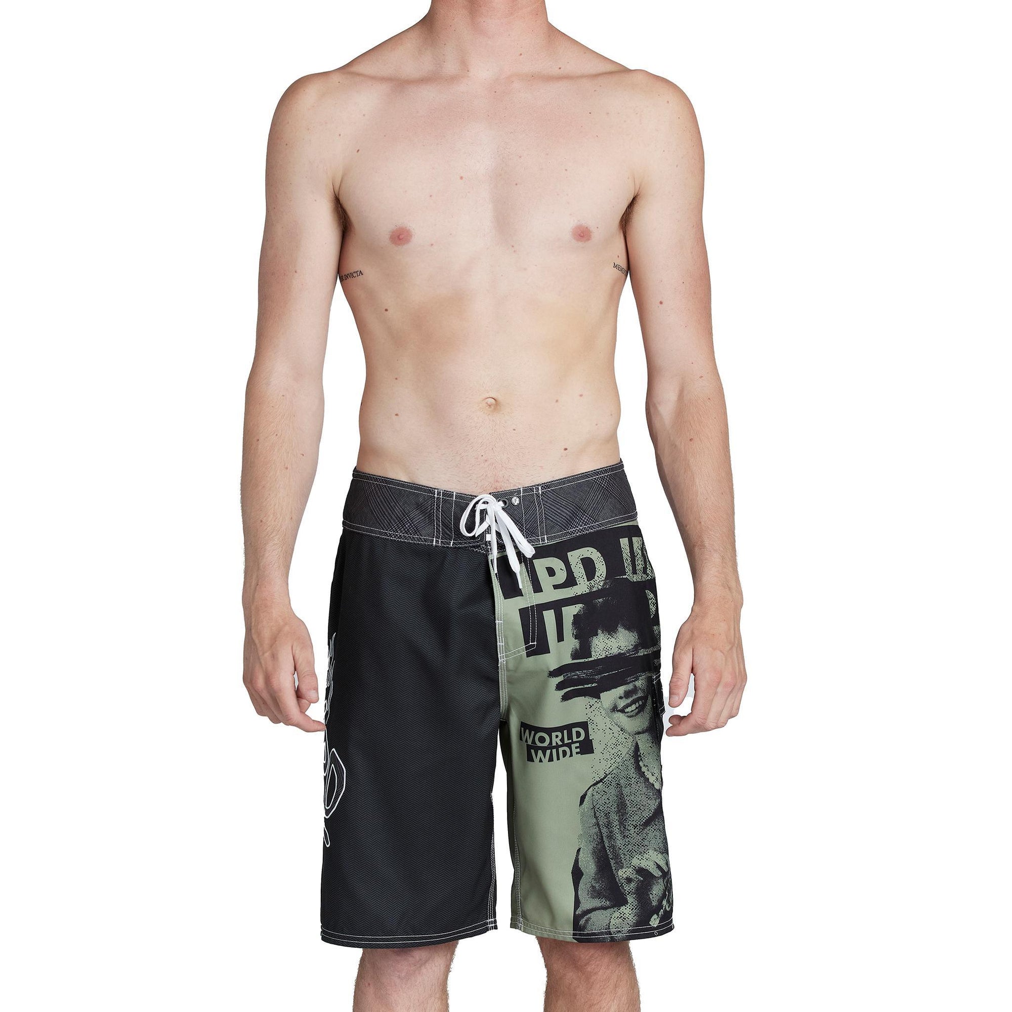 model wearing mens faceplant y2k fit 22" boardshort in black showing large graphic on left leg with woman surrounded by IPD logos and lerge IPD on right leg and tie closure on waist 