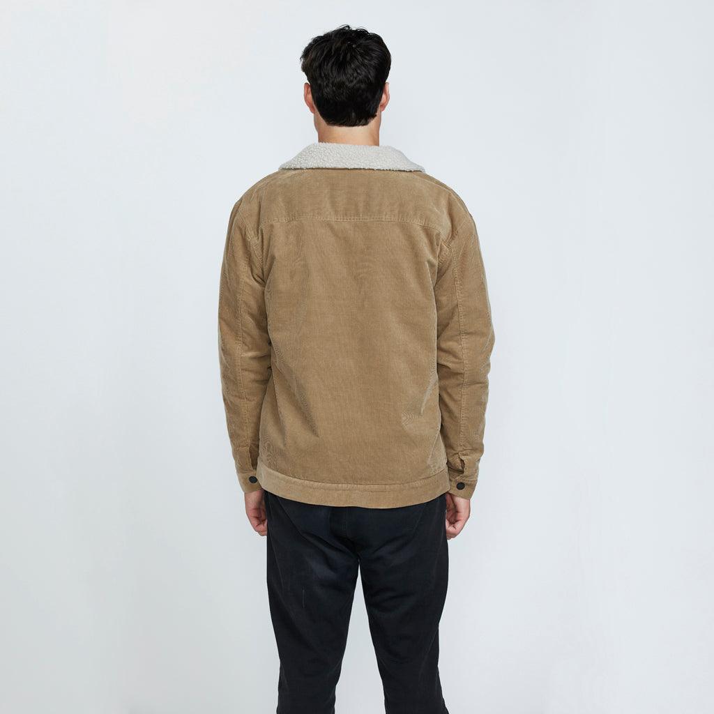 The back view of a man wearing a brown corduroy jacket with a sherpa collar.