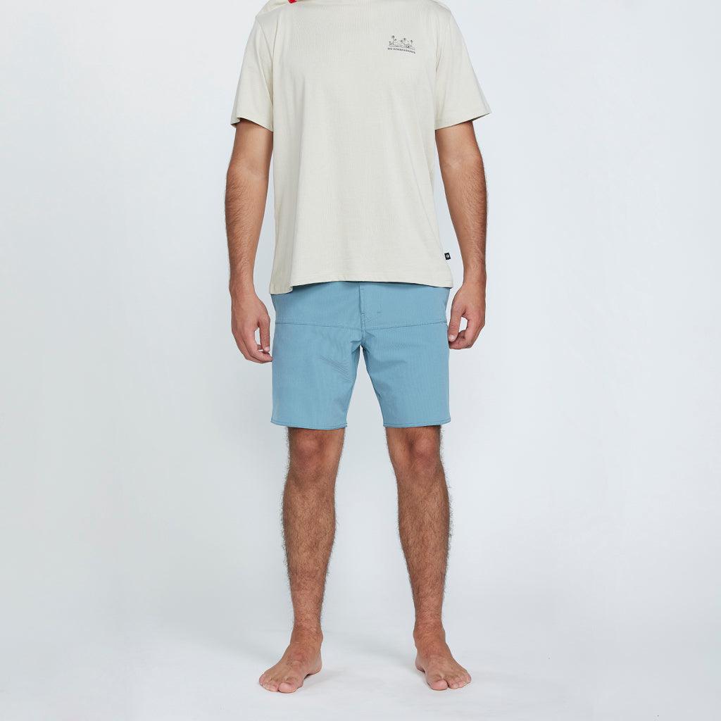 The front view of a man wearing blue shorts with two side pockets.