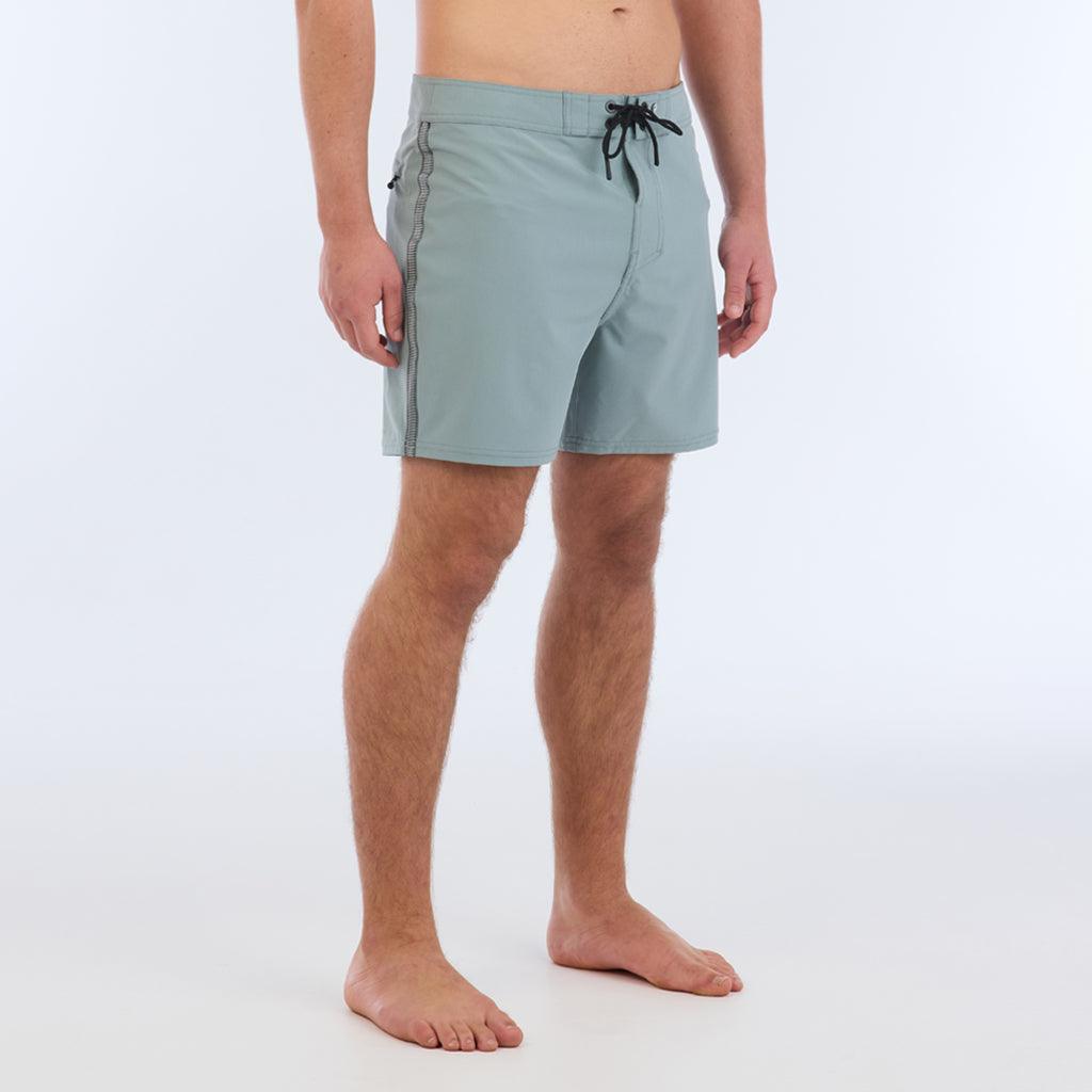The B100 Chase boardshort features a 16” length and solid sage coloring with a black and white striped side taping. It also has a waistband tie, side zipper pocket, and a black IPD logo patch halfway up the left leg taping.  